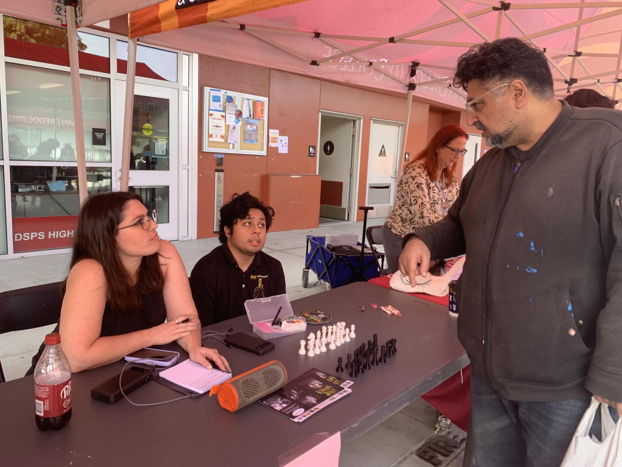Jeanette Lowrie, vice president of the Radio and Hardware Club, left, and Alexander Lopez, the club's president, center, talks to City College student Elad Gustavo, right, at the City College Valentine’s Day Club Rush event, Thursday, Feb. 12, 2026. Photo by Dianna Elbadawi/City Times Media