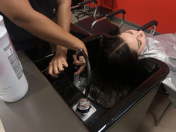 Sativa Groff, left, tests the water temperature before she washes City Times Media's Nadia Lavin's, right, hair at the V building, Friday, April 17, 2026. Photo by Naomi Lavin/City Times Media contributor