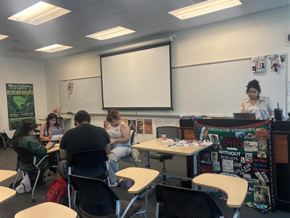 Chicano studies students work collaboratively on a Chicanoa/e/o history group project in the classroom of professor Norell Martínez, who stands at the lectern, April 6, 2025. Photo by Angela Galan Martinez/City Times Media