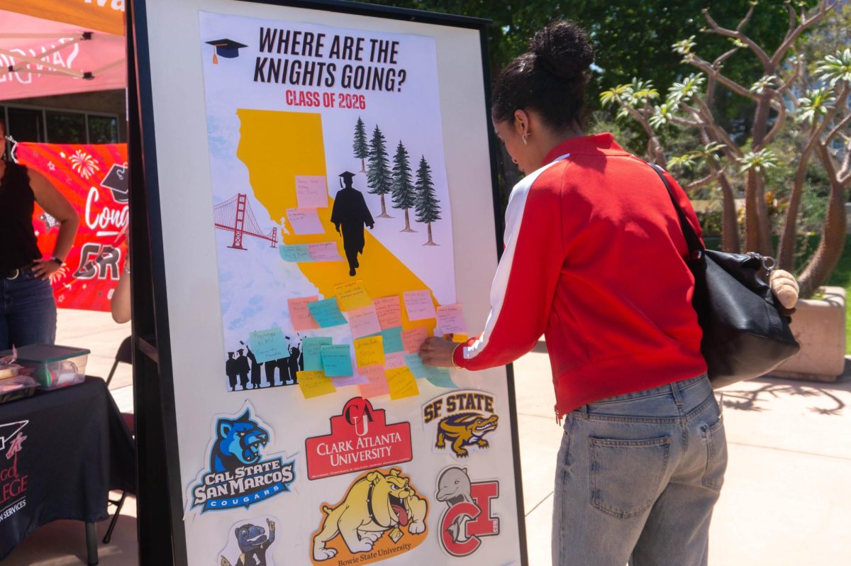 A board in the Gordon Plaza, “Where are the Knights going?” showcases sticky notes scattered with transfer students' future schools. Zion Marfo proudly places her future school, San Diego State University, on the board, Monday, May 11, 2026. Photo by Briana Bush/City Times Media