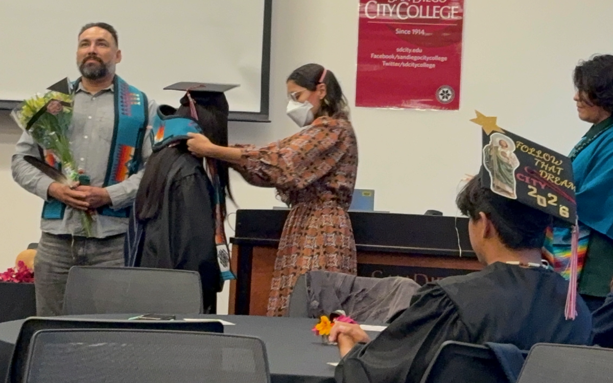  Student Anthony Azul, left, stands with his stole, a graduation gift, while student Valeria Netro, center left, accepts her own stole from student Taté Garcia, center, and student Ricardo Martinez Guerrero, right, watches the proceedings in room MS-140, Tuesday, May 12, 2026. Photo by Crow Ruiz/City Times Media